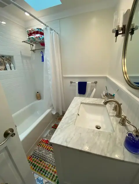 Small bathroom with tub and marble vanity