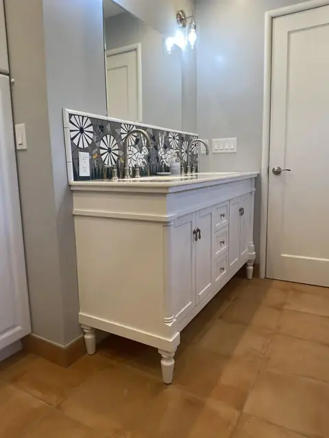 White vanity with patterned tile backsplash